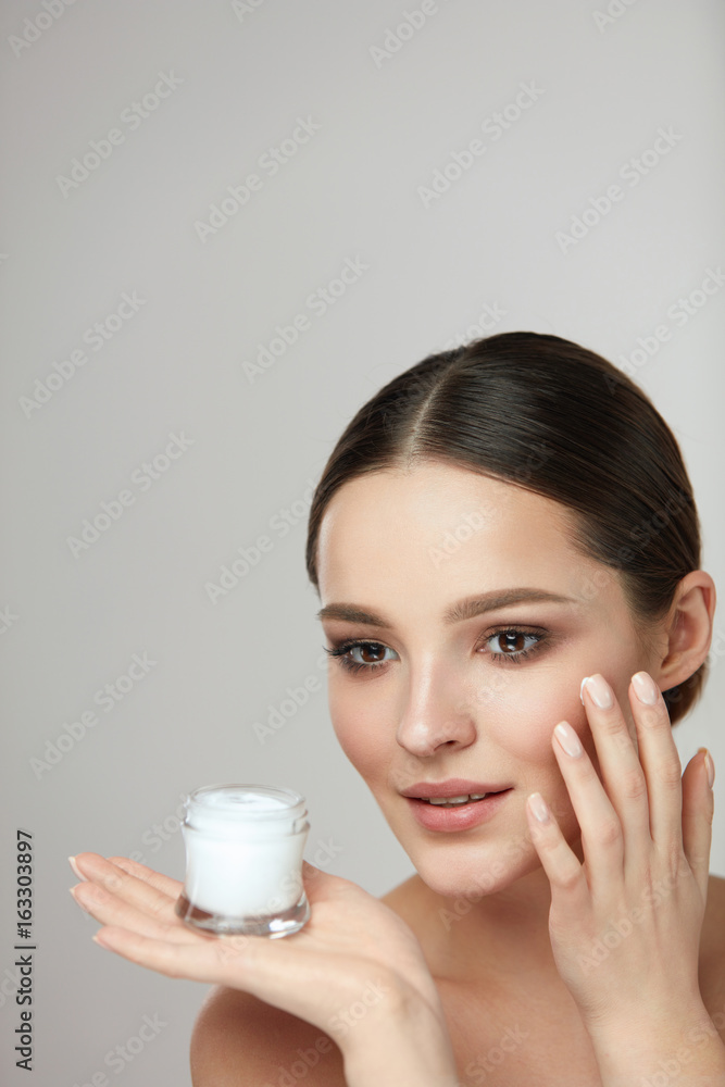 Woman Beauty Cosmetics. Beautiful Female Applying Cream On Face Woman Beauty Cosmetics. Beautiful Female Applying Cream On Face