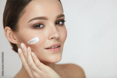 Beautiful Woman Face With Cream On Fresh Soft Skin. Cosmetics
