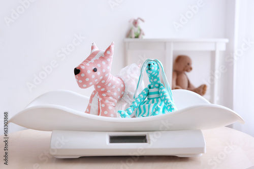 Baby scales with toys on ta...