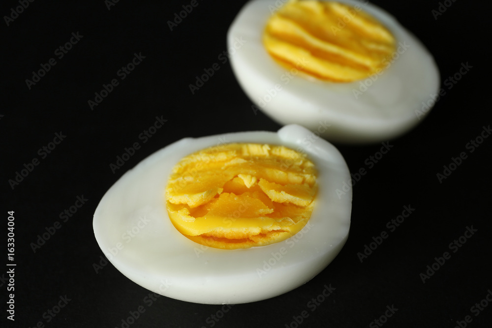 Sliced hard boiled egg on black background. Nutrition concept Sliced hard boiled egg on black background. Nutrition concept