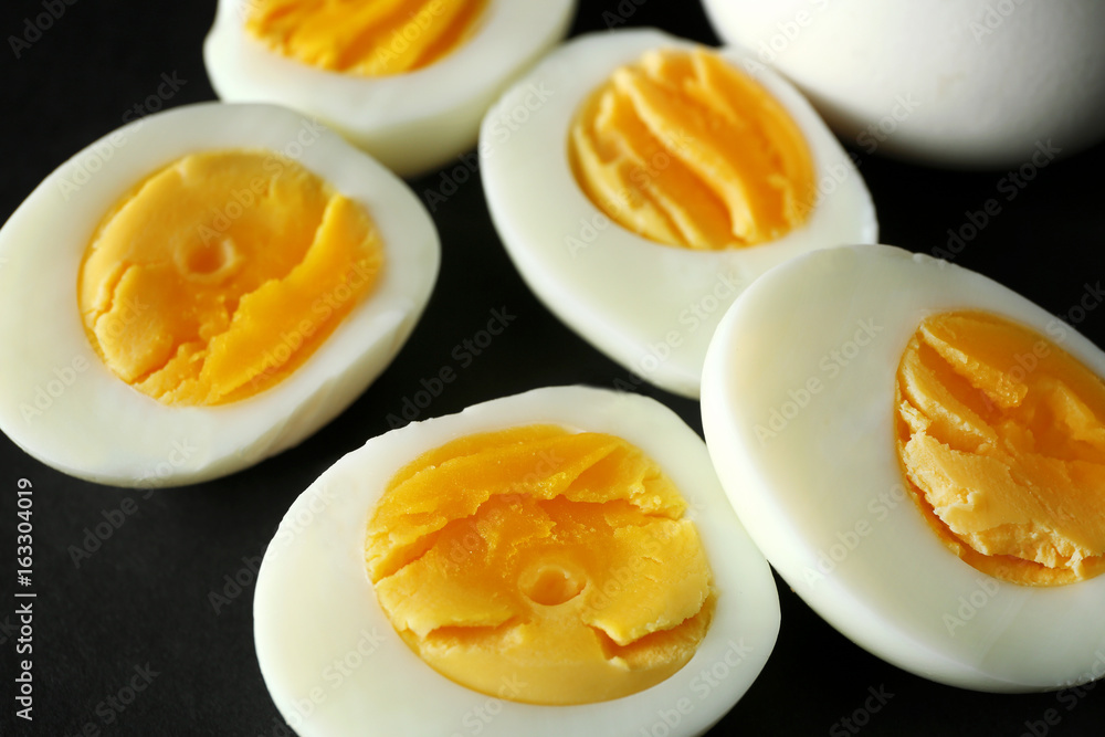 Sliced hard boiled eggs on black background. Nutrition concept Sliced hard boiled eggs on black background. Nutrition concept