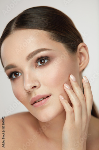 Cosmetic Face Care. Young Woman Caressing Facial Skin