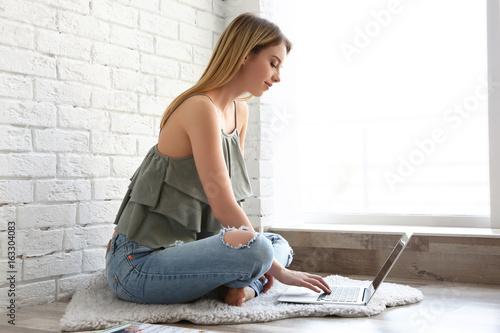 Young girl sitting on rug a...
