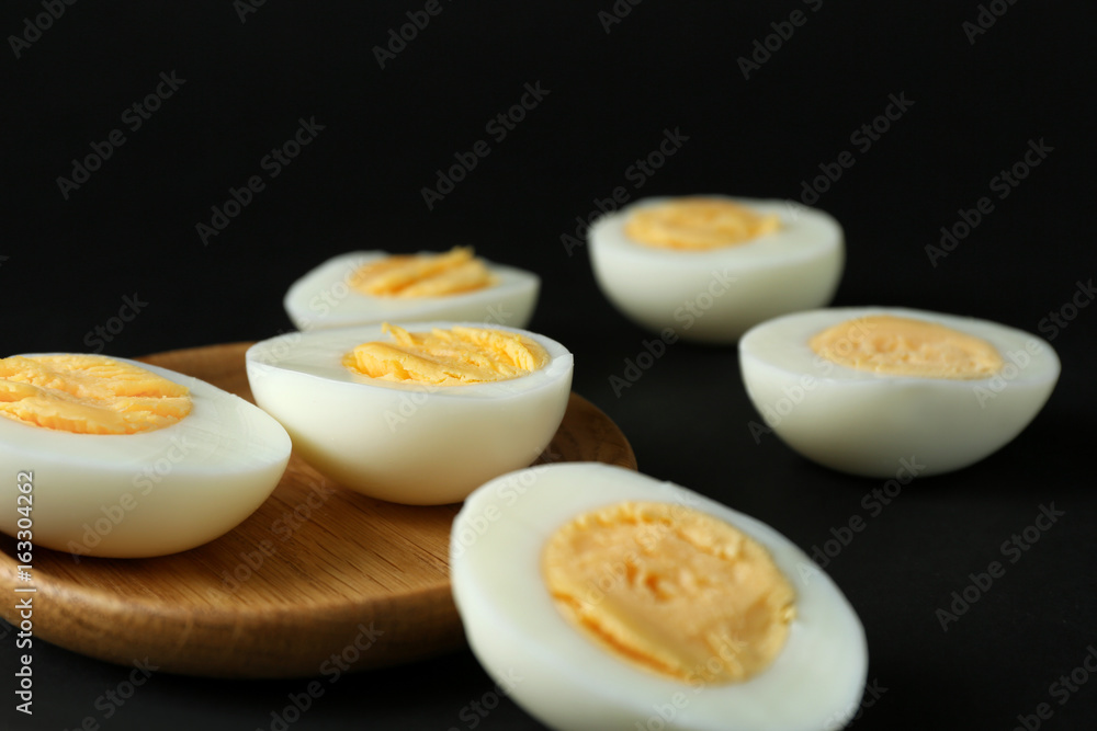 Wooden tray and hard boiled eggs on black background. Nutrition concept Wooden tray and hard boiled eggs on black background. Nutrition concept