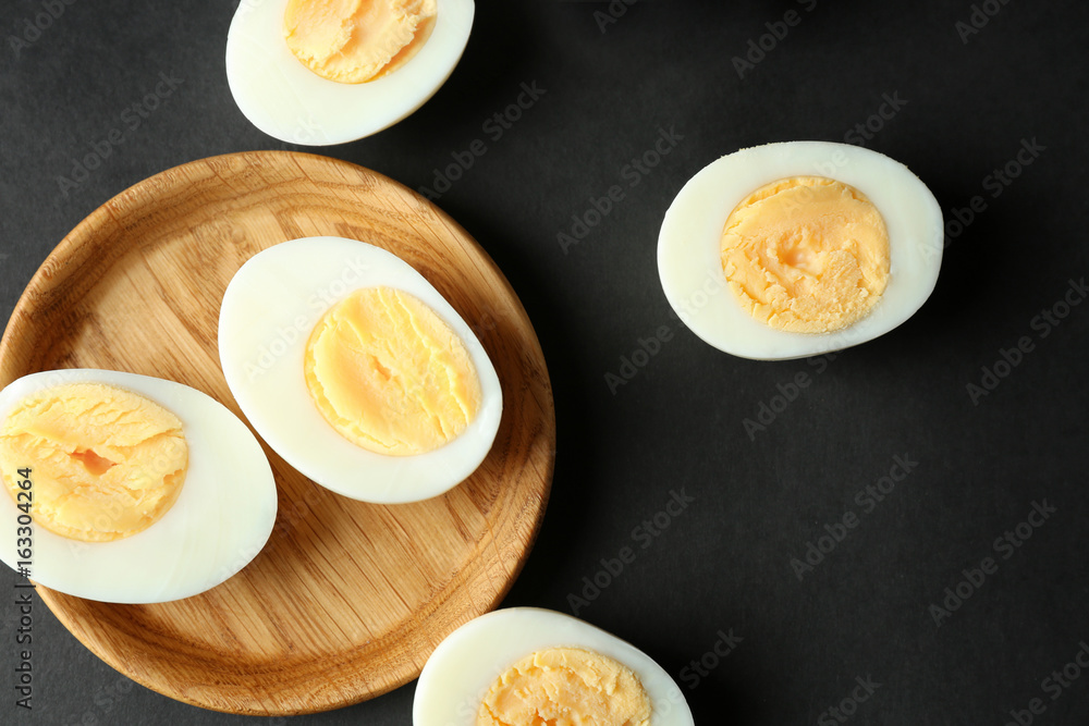 Wooden tray and hard boiled eggs on black background. Nutrition concept Wooden tray and hard boiled eggs on black background. Nutrition concept
