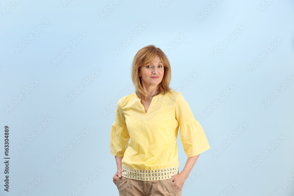 Portrait of attractive mature woman on light blue background Portrait of attractive mature woman on light blue background