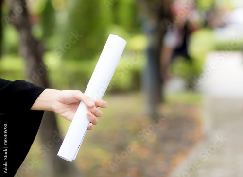 Diploma in hand on nature background