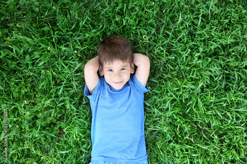 Cute little boy lying on gr...