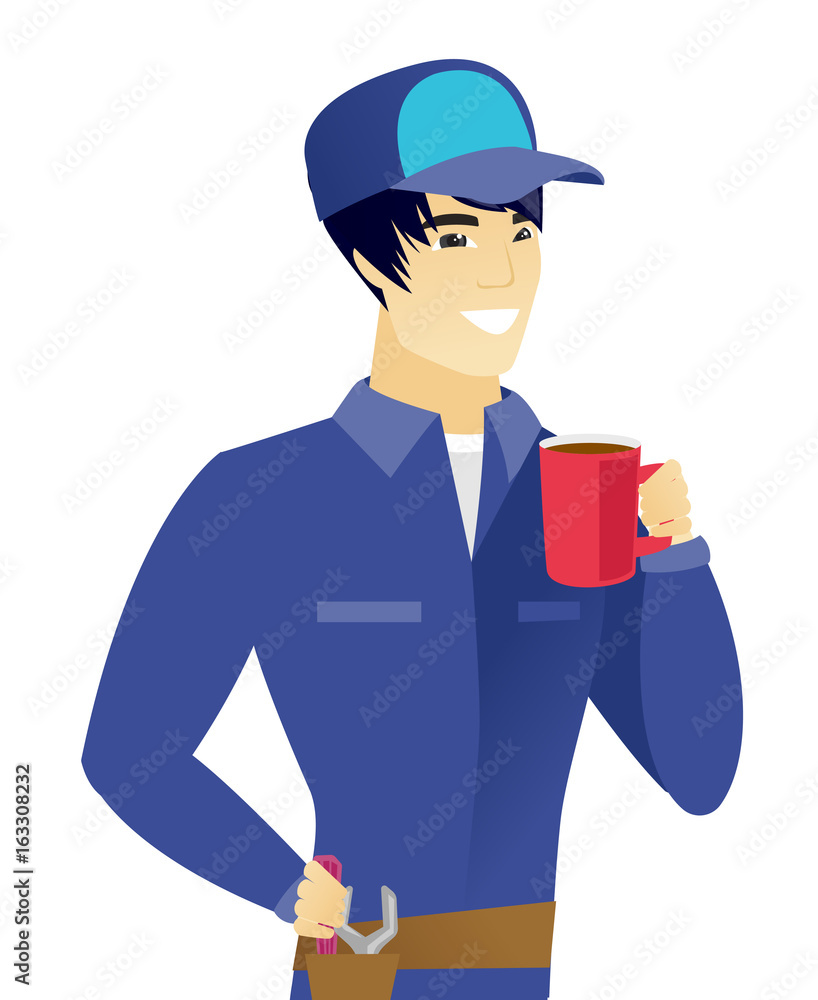 Young asian mechanic holding cup of coffee.
