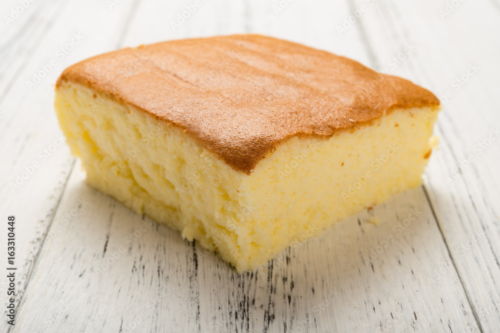 side view sponge cake on white wood background side view sponge cake on white wood background
