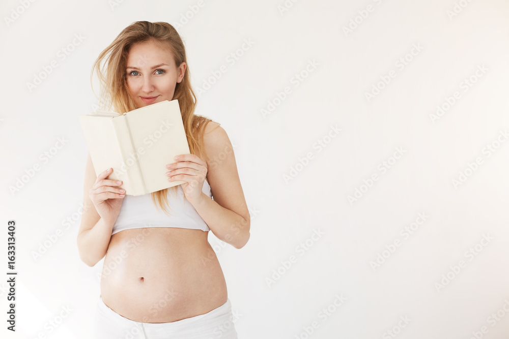 Pregnant woman reading a book on healthy food and breastfeeding or just relaxing taking her time on a maternity leave. Pregnant woman reading a book on healthy food and breastfeeding or just relaxing taking her time on a maternity leave.