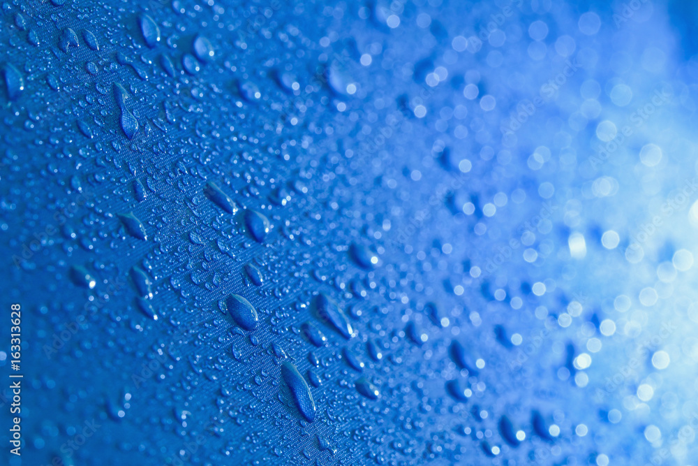 Obraz premium Rain Water droplets on blue waterproof fabric