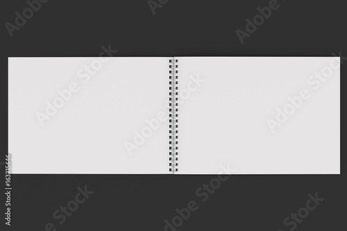 Open blank white notebook with metal spiral bound on black background