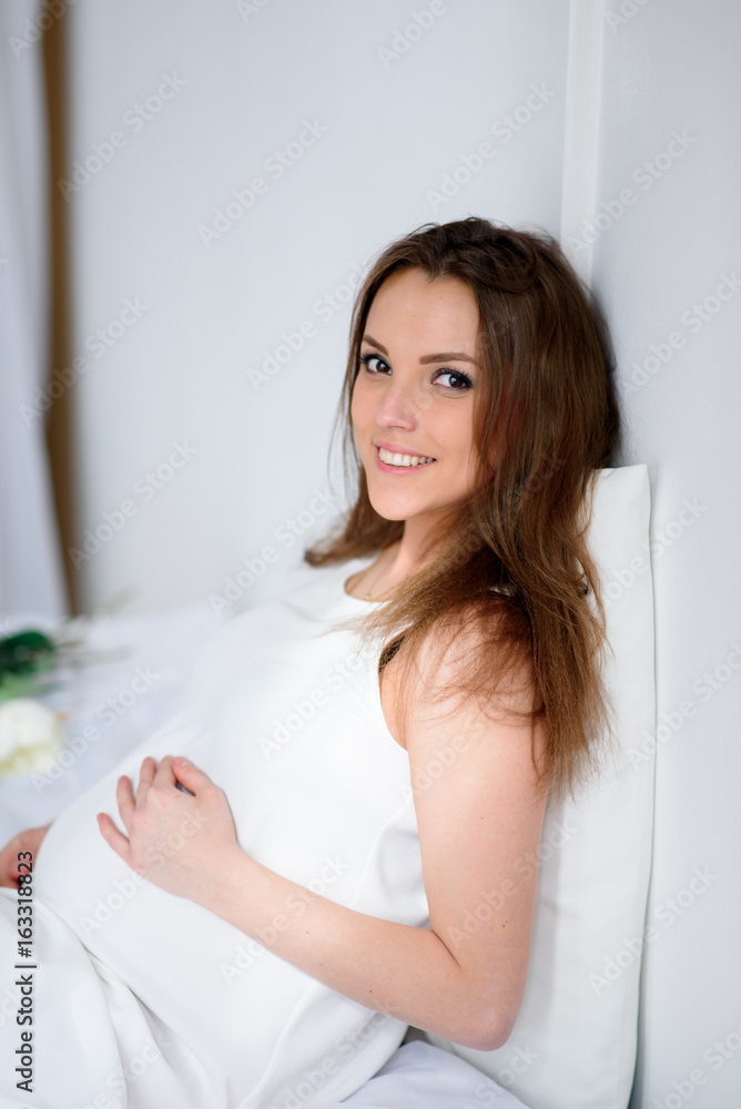 Happy pregnant girl in white dress. Happy pregnant girl in white dress.
