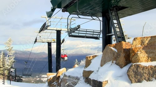 Ski lift at top of Bretton Woods in white mountains of New Hampshire during midweek with minimal crowd.  View of Mt Washington in distance.  Includes audio. 