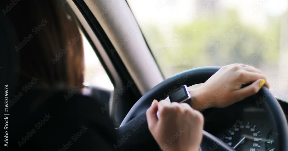 Closeup of woman girl using smart watch on her hands while driving a car, vintage tone, urban background, technology innovation 4k Closeup of woman girl using smart watch on her hands while driving a car, vintage tone, urban background, technology innovation 4k
