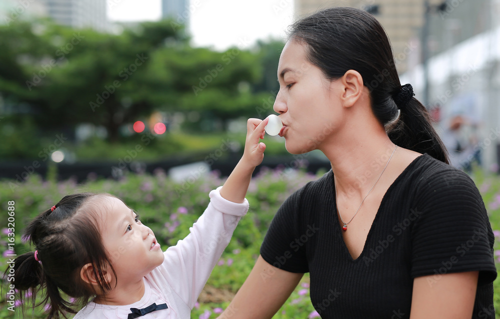 Mother and child girl kissing on bubble gum. Happy loving family. Mother and child girl kissing on bubble gum. Happy loving family.
