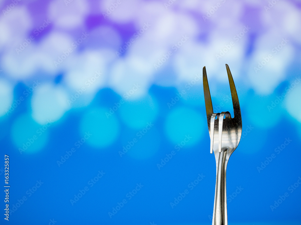 Stainless steel fork is gesture meant to convey love on natural light bokeh background. Stainless steel fork is gesture meant to convey love on natural light bokeh background.