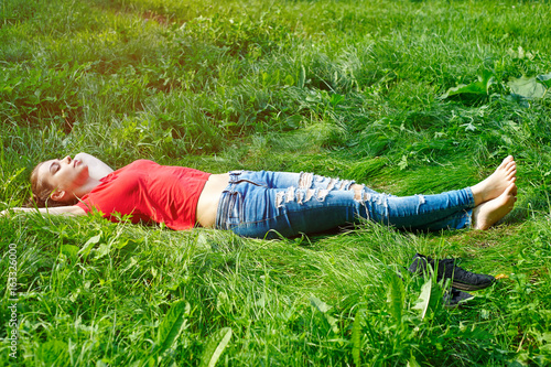 The woman lies on the grass