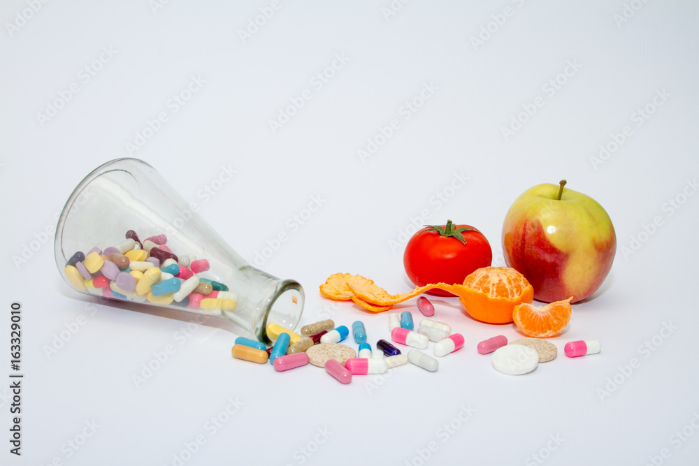 Colorful medical pills in a glass container on a white background. Colorful medical pills in a glass container on a white background.
