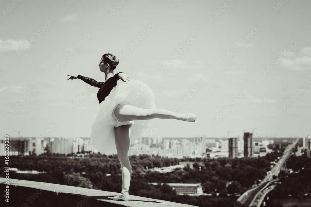 Fototapeta A gorgeous european young woman ballet dancer in city, inspiration for other people. Looks like princess have grace and body plastic dancing on outdoors 