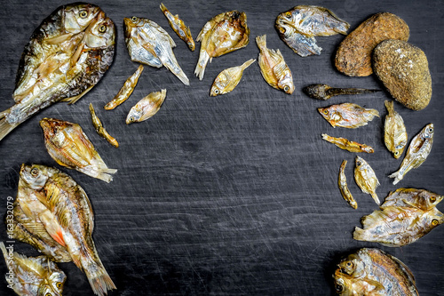 Dry fish with sunny on black wooden floor, small dried fish and pattern of dried fish, top view of dry fish on table photo