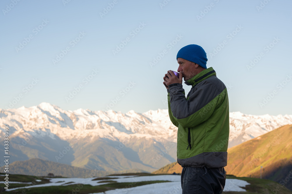 Meditative traveler drinking coffee and watching a sunrise