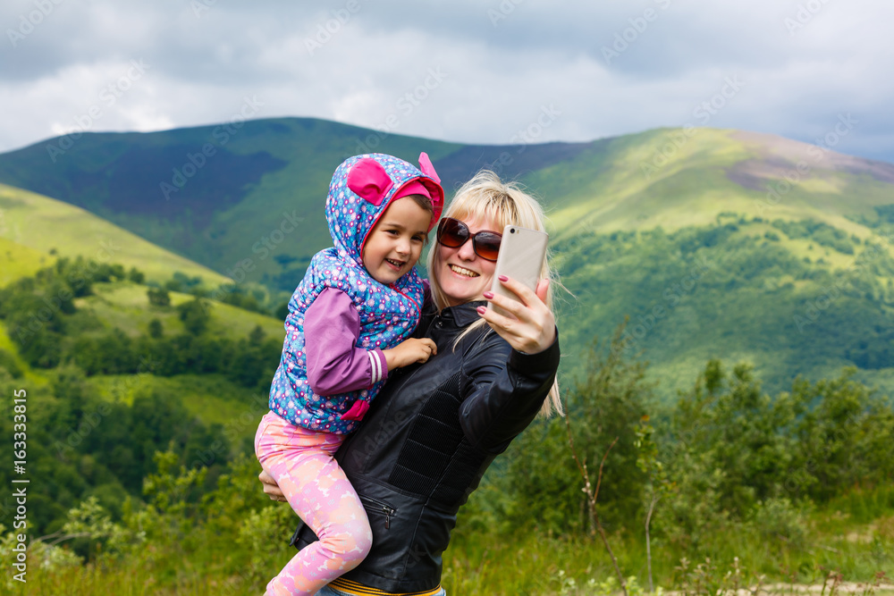 Mother and daughter taking selfie photograph together