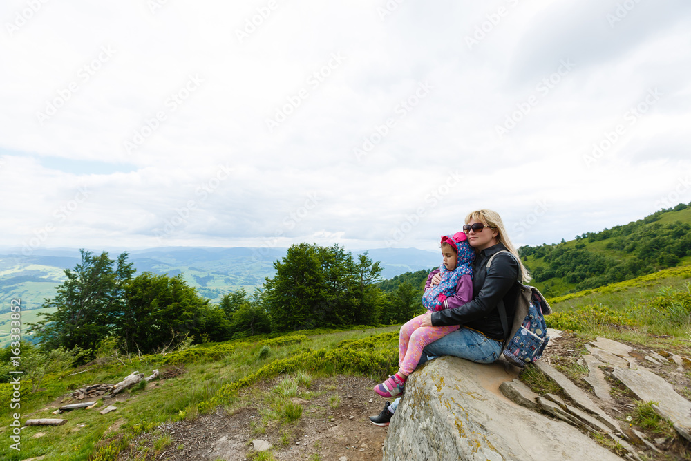 Mother and daughter admire beauty in the mountains
