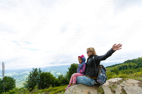 Mother and daughter admire beauty in the mountains © Angelov