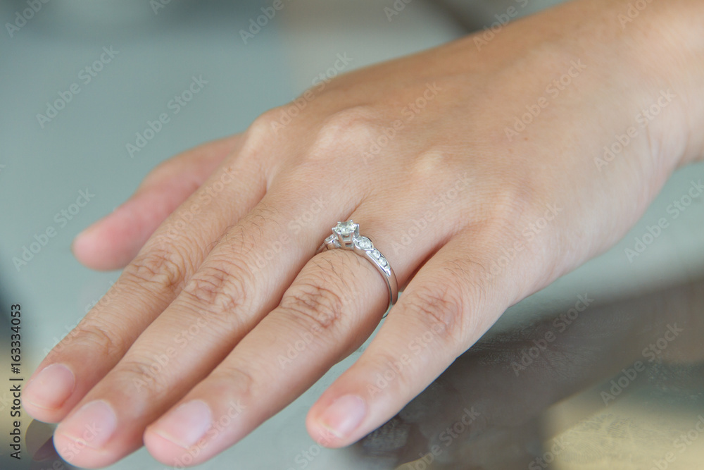 Diamond ring on female finger Diamond ring on female finger