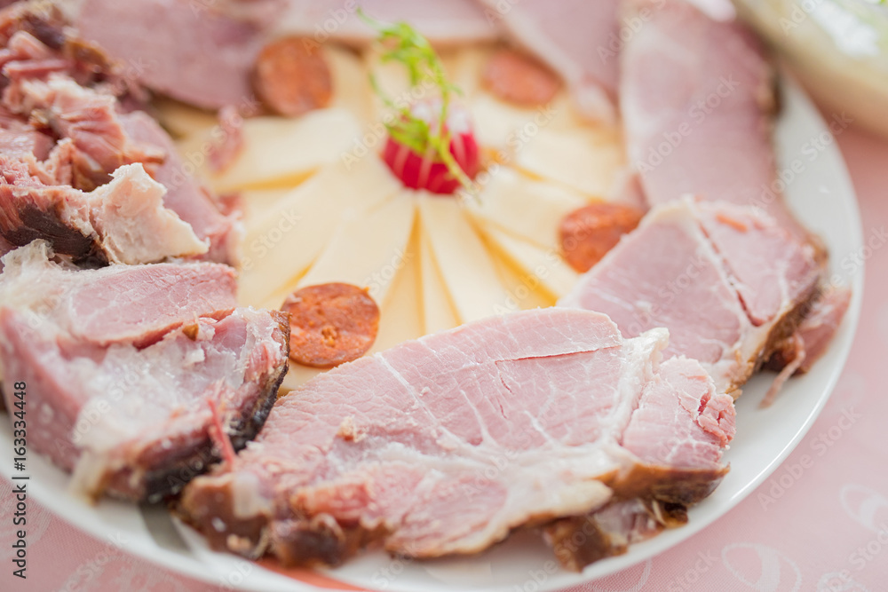 Slices of cooked ham on plate.