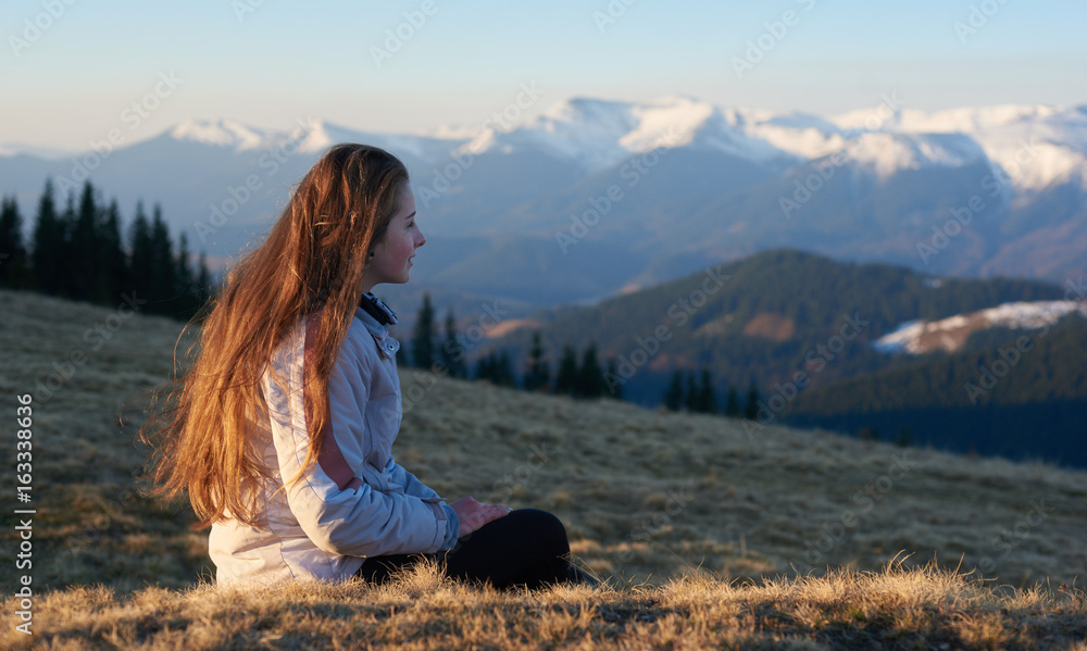Young woman enjoying sunrise in the mountains after morning hike copyspace nature travel tourism sport freedom happiness achieving relaxation recreation