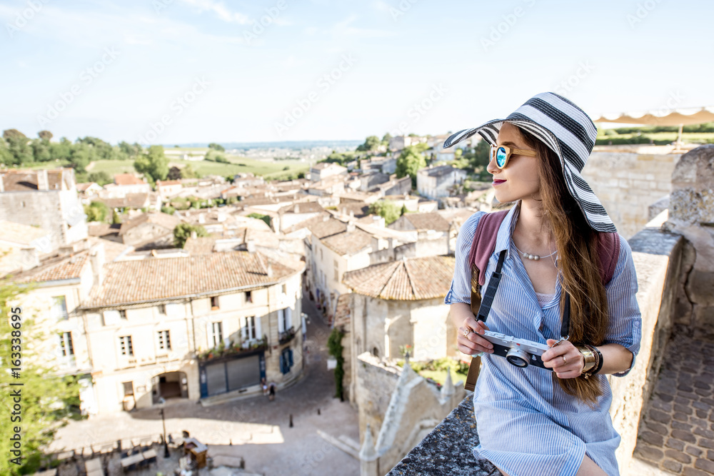 Young woman tourist enjoying beautiful cityscape view on Saint Emilion village in Bordeaux region in France