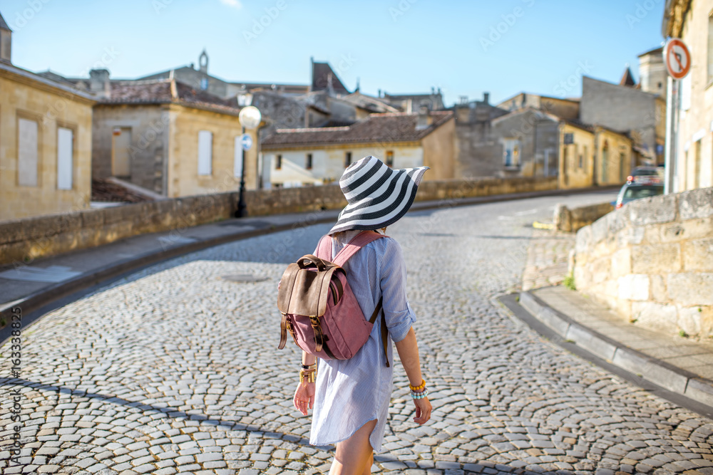 Young woman tourist walking old street at the famous Saint Emilion village in Bordeaux region in France