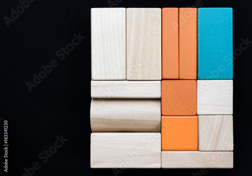 Sorted wooden blocks on black background. Copy space photo