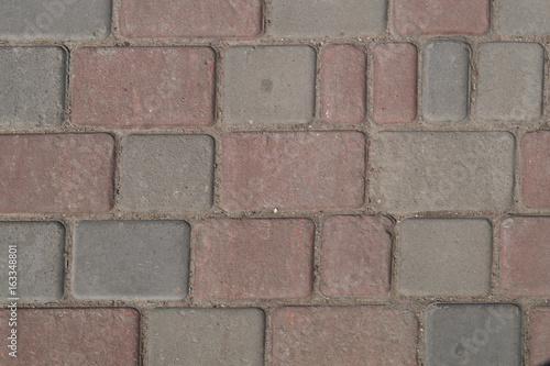 Grey and half-light pink cobbles on the sidewalk, background, texture