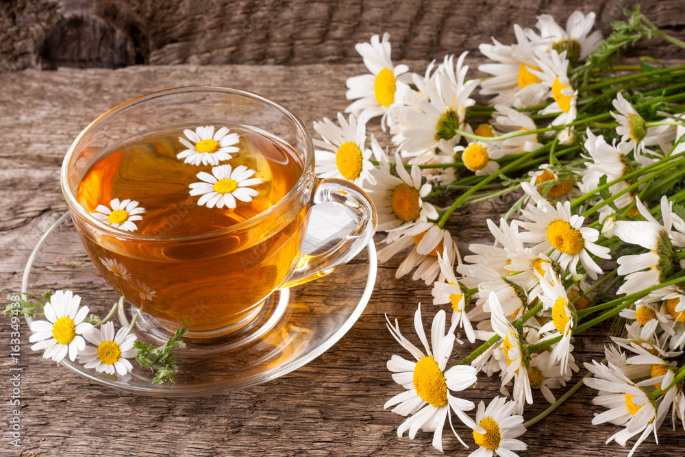 Herbal tea with fresh chamomile flowers on old wooden background Herbal tea with fresh chamomile flowers on old wooden background