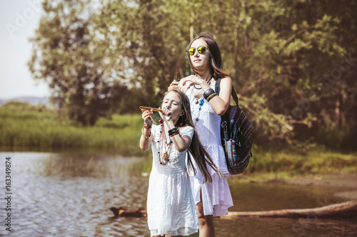 Beautiful and happy young mother and little daughter on nature bright Sunny day together © kuzmichstudio