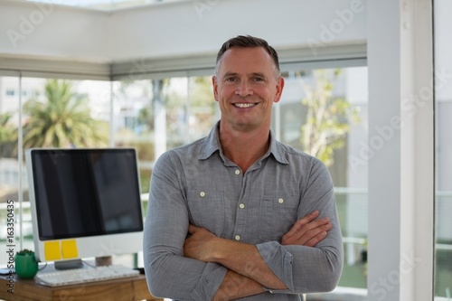 Portrait of confident businessman with arms crossed standing