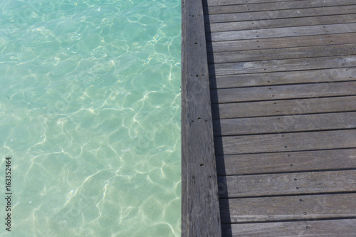 Wooden pier over clear blue sea © ink drop