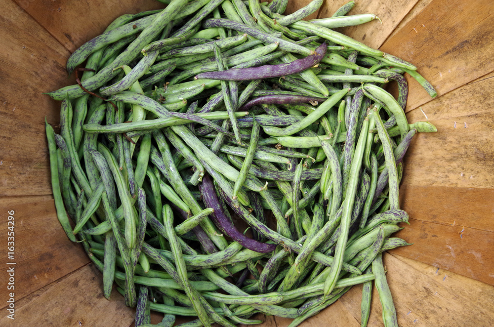 Dragon tongue beans in wooden basket viewed from above Dragon tongue beans in wooden basket viewed from above