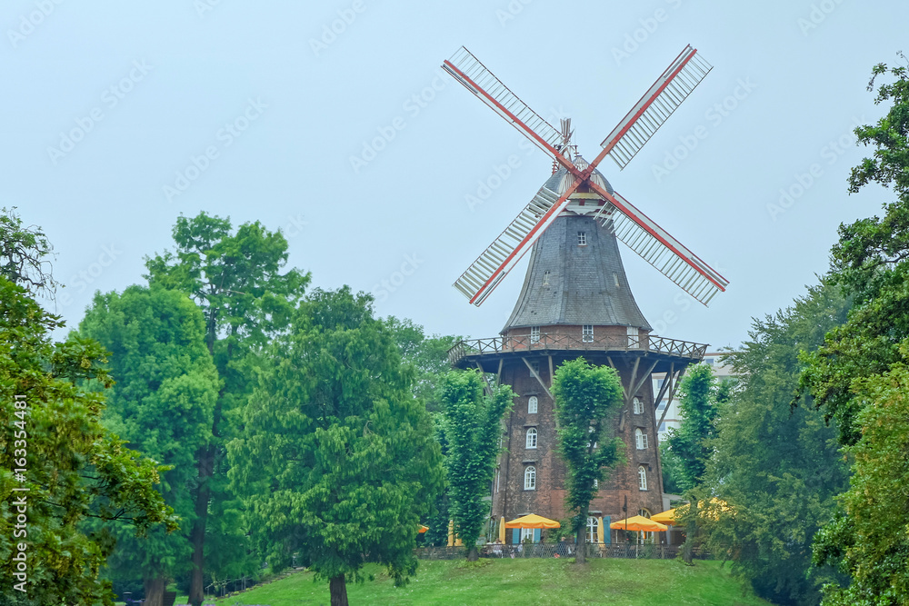 old wind mill among the green trees in the Park old wind mill among the green trees in the Park