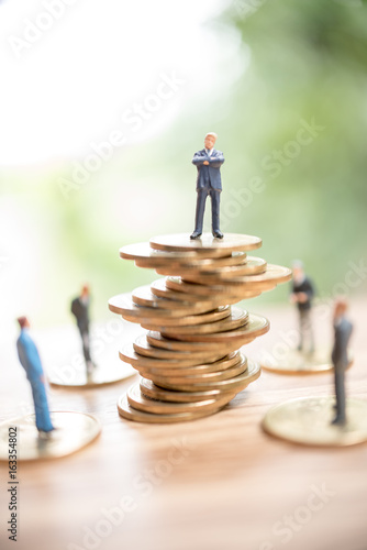 Miniature people standing on stack of coin,Business concept