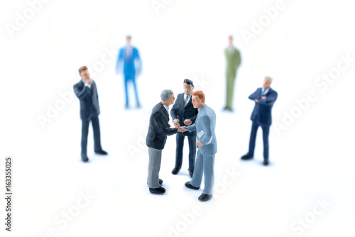 Miniature people shaking hands, Business concept.