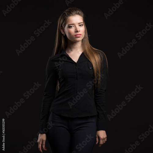 Young sexy woman portrait of a confident businesswoman showing presentation on a black background. Ideal for banners, registration forms, presentation, landings, presenting concept..