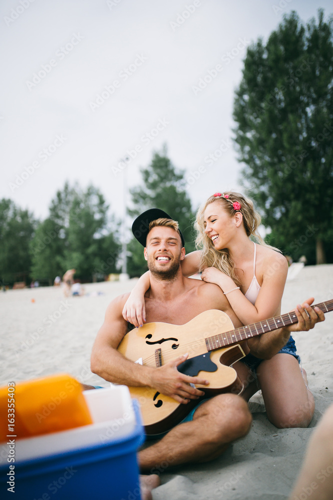 Young attractive couple enjoying in holiday on beach and having fun. 
