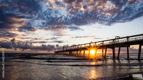 Sand pumping jetty at sunrise with star burst