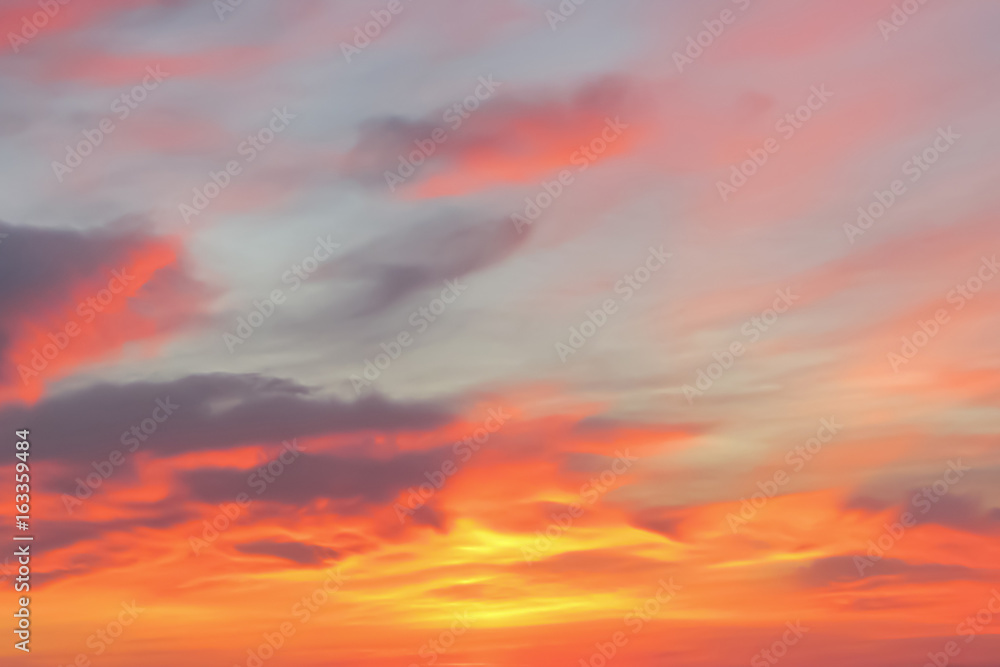 Bright orange, pink and dark clouds in the sky at sunrise or sunset