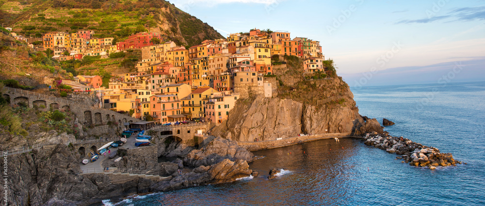 Charming beautiful landscape panorama with bright colored houses on the rock on the seafront of Manarola